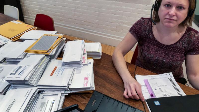 Kimberly George sitting with envelopes and notebook