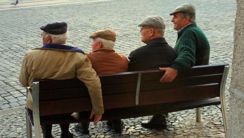 Four elderly men sitting on a bench